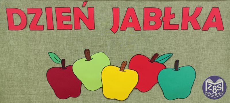 Czerwony napis Dzień Jabłka na zielonym tle. Pod napisem jest pięć dużych jabłek w kolorach: bordowym, jasno zielonym, żółtym, czerwonym, ciemno zielonym
